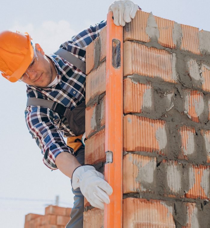 Young craftsman building a house