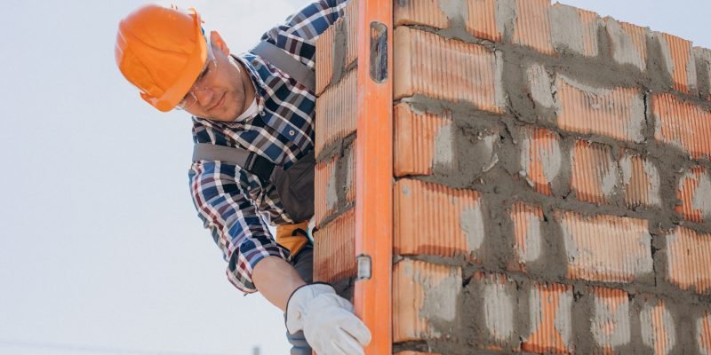 Young craftsman building a house